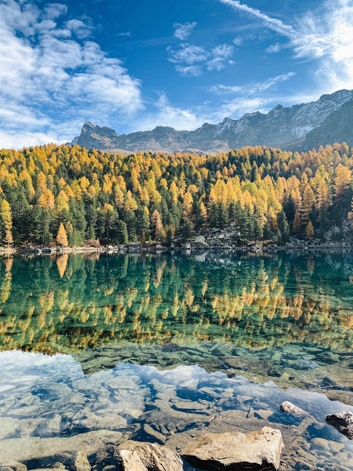 Beautiful mountain lake in Switzerland with vibrant fall colors and clear reflections.