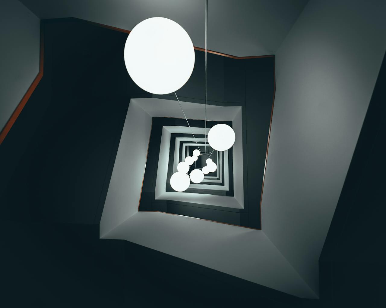 A mesmerizing view of spiral staircase with modern geometric lighting design.